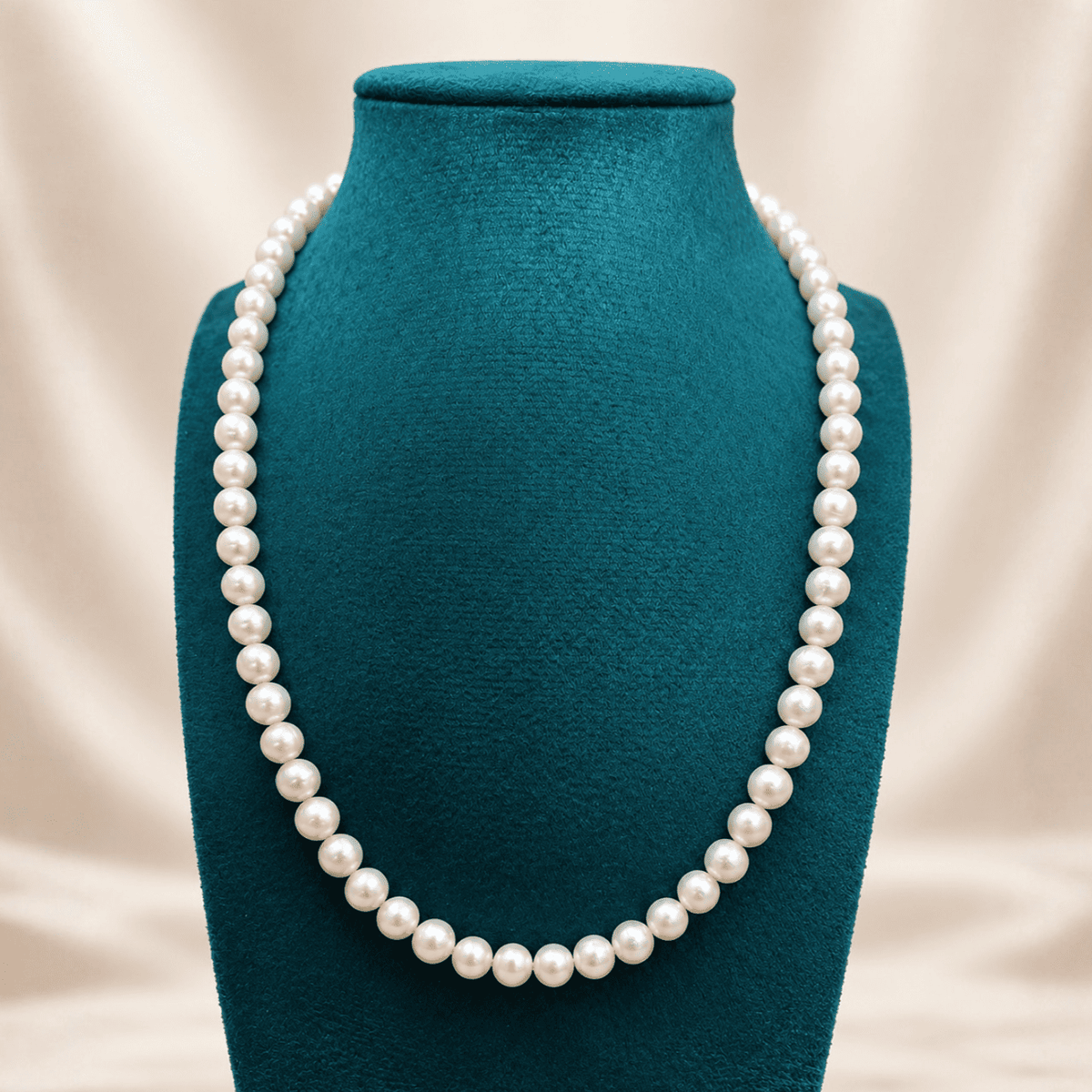 שרשרת פנינים אמיתיות NOCTURNE PEARLS בעבודת יד, מוצגת על בוסט קטיפה טורקיז, עם פנינים לבנות בעלות ברק טבעי - תכשיטי גלאם אנד ג'אמס | GLAM N’ GEMS